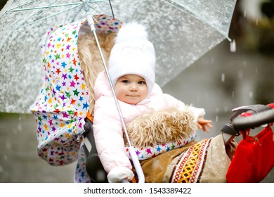 Cute Little Beautiful Baby Girl Sitting In The Pram Or Stroller On Cold