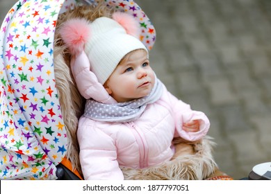 Cute Little Beautiful Baby Girl Sitting In The Pram Or Stroller On Cold