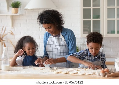 Cute Little Black Kids Helping Mom To Bake Cookies. Mother And Sibling Children Cooking Together, Preparing Dough For Homemade Biscuits At Flour Table, Using Cutters. Family Household Activities