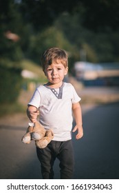 Cute, Little, Blond Boy Holding Teddy Bear In Hand. Imaginary Friend