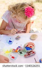 Cute Little Blond Child Having Fun With Painting Stones