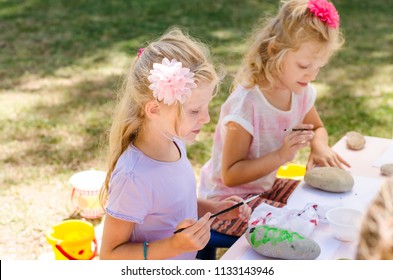 Cute Little Blond Girls Having Fun With Painting Stones