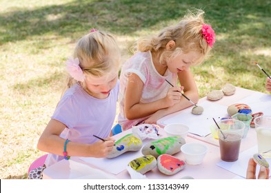 Cute Little Blond Girls Having Fun With Painting Stones