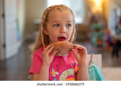 Cute Little Blonde Girl Licking A Jelly Donut