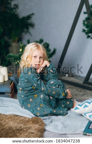 Cute little blonde girl posing at the Christmas tree. Happy new year concept. Toning.