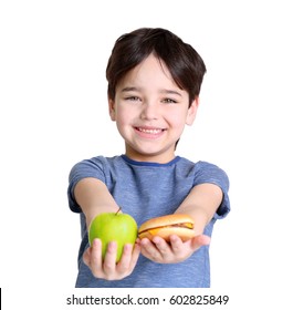 Cute little boy with apple and hamburger on white background