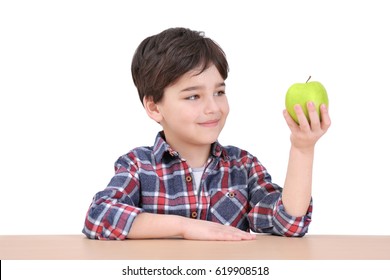 Cute little boy with apple sitting at table, on white background - Powered by Shutterstock