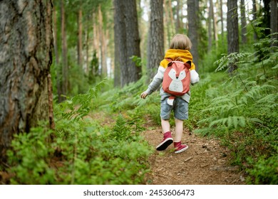 Cute little boy with a backpack having fun outdoors on sunny summer day. Child exploring nature. Kid going on a trip. Summer activities for families with kids. - Powered by Shutterstock