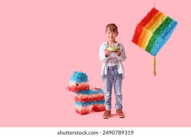 Cute little boy with Birthday cake and pinatas on pink background - Powered by Shutterstock