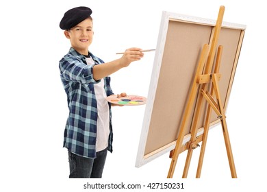 Cute Little Boy With A Black Beret Painting On A Canvas And Looking At The Camera Isolated On White Background