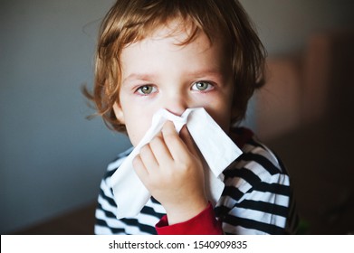 Cute Little Boy Blowing His Nose Into A Handkerchief.