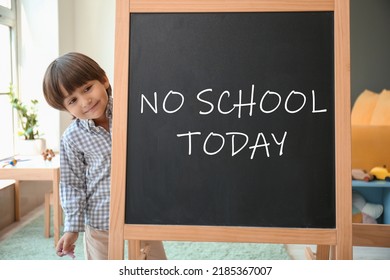 Cute little boy and chalkboard with written text NO SCHOOL TODAY in classroom - Shutterstock ID 2185367007