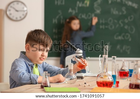 Similar – Image, Stock Photo Serious little boy playing with chemical liquids