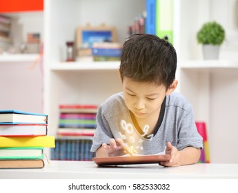 Cute little boy with digital tablet, early learning.asian boy playing game in livingroom.