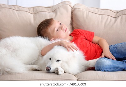 Kleiner Junge mit Hund zu Hause