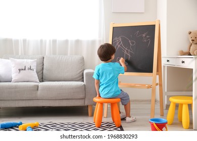 Cute little boy drawing on blackboard in kindergarten - Powered by Shutterstock