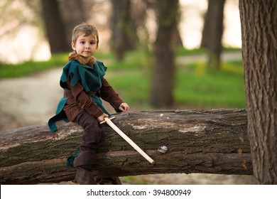 Cute little boy dressed up as a knight playing in the woods with a handmade sword - Powered by Shutterstock