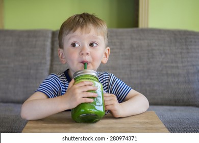 Cute Little Boy Drinking A Green Smoothie