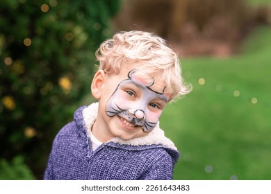 Cute little boy with face paint. Face painting, kid painting face at the birthday party or on holidays - Powered by Shutterstock