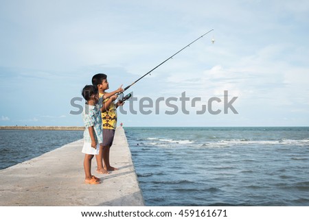 Cute little boy fishing at sea