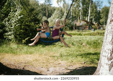 cute little boy and girl having fun on a spiderweb tree swing at playground. Summer vacation in the nature. - Shutterstock ID 2269233955