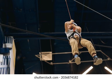 cute little boy going down on zipline in adventure park passing obstacle course. high rope park indoors. High quality photo - Powered by Shutterstock