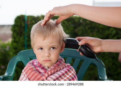 Cute, little boy in the hairdressing salon, during cutting hair.