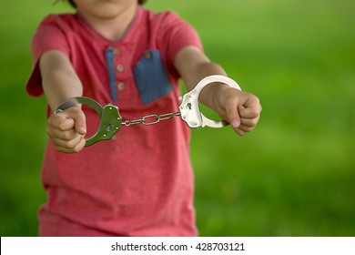 Cute Little Boy With The Hand Cuffs On His Hands, Playing