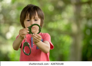 Cute Little Boy With The Hand Cuffs On His Hands, Playing