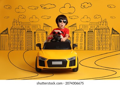 Cute Little Boy With His Dog In Toy Car And Drawing Of City On Yellow Background