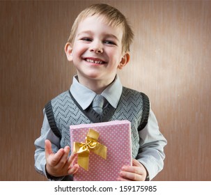 Cute Little Boy Holding Gift Box With Bow