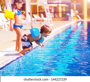 Cute little boy jumping into the pool, brother and sister having fun in poolside, water amusement, luxury beach resort, summer vacation, happy childhood - Powered by Shutterstock