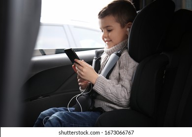 Cute Little Boy Listening To Audiobook In Car