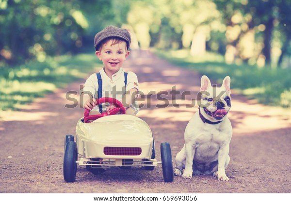 cute Little Boy in pedal car with his\
best friend dog                                    \
