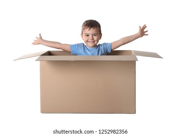 Cute little boy playing with cardboard box on white background