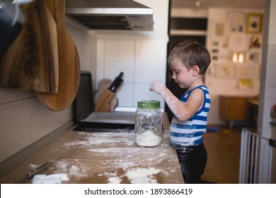 Cute Little Boy Playing With Flour And Making Mess In Kitchen