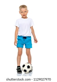 Cute Little Boy Is Playing And Posing In The Studio With A Soccer Ball. The Concept Can Be Used To Advertise Football Clubs, Sports Outfits, Healthy Lifestyles. Isolated On White Background.