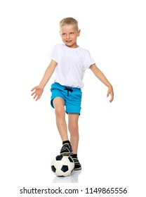 Cute Little Boy Is Playing And Posing In The Studio With A Soccer Ball. The Concept Can Be Used To Advertise Football Clubs, Sports Outfits, Healthy Lifestyles. Isolated On White Background.