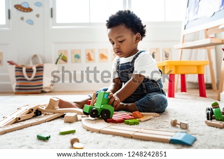 Cute little boy playing with a railroad train toy