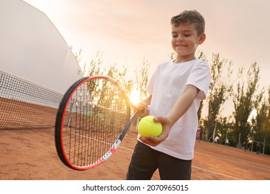 Cute little boy playing tennis on court outdoors - Powered by Shutterstock