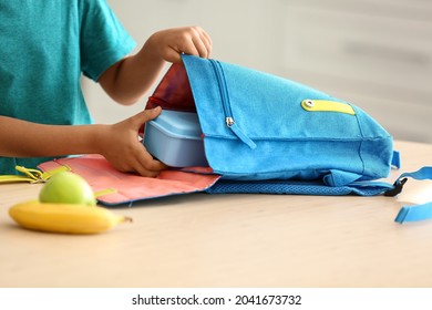 Cute Little Boy Putting His School Lunch In Bag