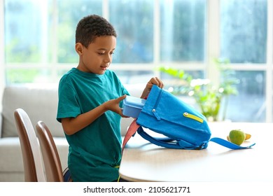 Cute little boy putting his school lunch in bag - Shutterstock ID 2105621771
