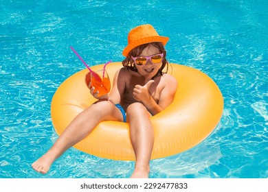 Cute little boy relaxing with toy ring floating in a swimming pool having fun on summer vacation. Happy child playing in swimming pool. Kid floating in pool. Child relaxing in pool, drink cocktail. - Powered by Shutterstock