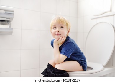 Cute little boy in restroom. Toddler child trainig use toilet. Hygiene for little child
