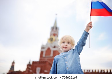 Cute Little Boy With Russian Flag With Spasskaya Tower Russia, Moscow On Background. Patriotic Feeling/patriotism Concept