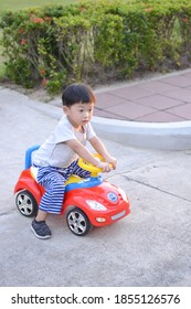 Cute Little Boy  Sits On A Toy Car 