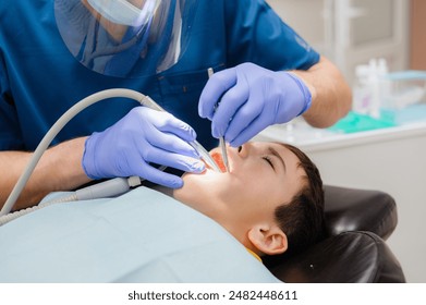 Cute little boy is sitting in a dental chair with a scared expression on his face, afraid to treat his teeth. Prevention of diseases of baby teeth in children. - Powered by Shutterstock