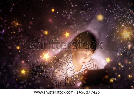 Similar – Boy reading with a flashlight