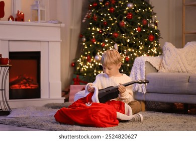 Cute little boy taking ukulele from Santa bag at home on Christmas eve - Powered by Shutterstock