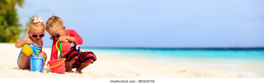 Cute Little Boy And Toddler Girl Play On Beach